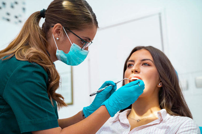 Dentist performing a teeth cleaning on a patient during a dental checkup