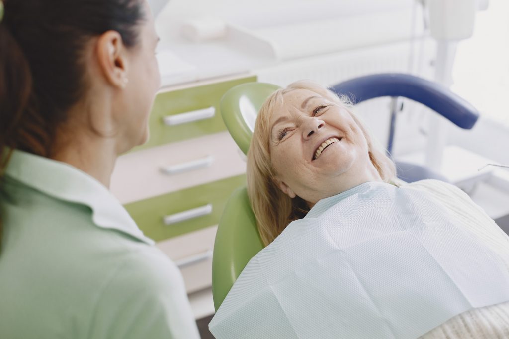 senior dental patient sitting in the chair looking at the dentist